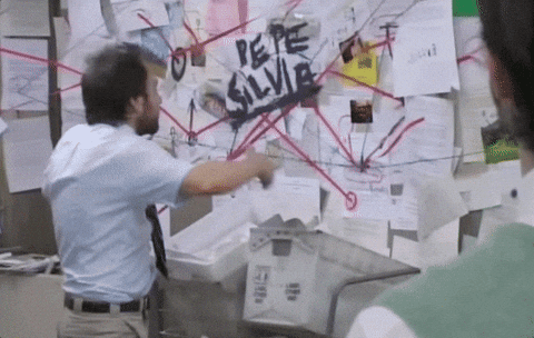 Reaction Gif of Charlie from "Always Sunny in Philadelpha", chaotically gesturing in front of a pinboard with red strings.